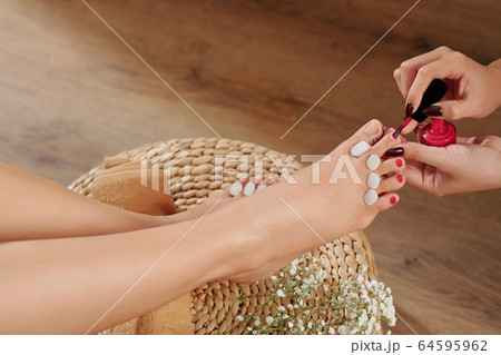 Beautician applying nail polish 64595962
