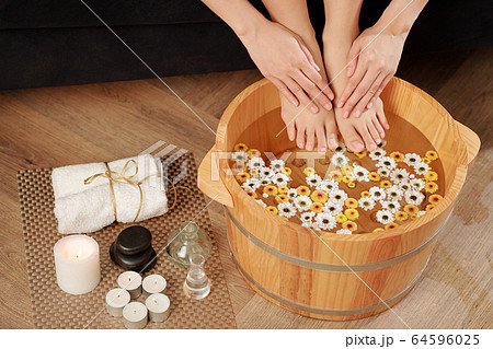 Woman putting feet and hands in basin 64596025