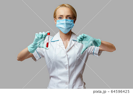 medical doctor nurse woman wearing protective mask and gloves - holding virus blood test medical doctor nurse woman wearing protective mask and gloves - holding virus blood test 64596425