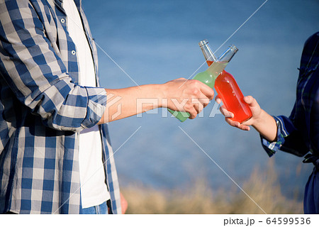 Young couple in love enjoying cocktail at the beach Young couple in love enjoying cocktail at the beach 64599536