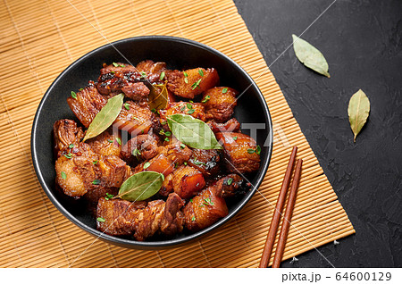 Adobo Pork in black bowl at black dark background. filipino food Adobo Pork in black bowl at black dark background. filipino food 64600129