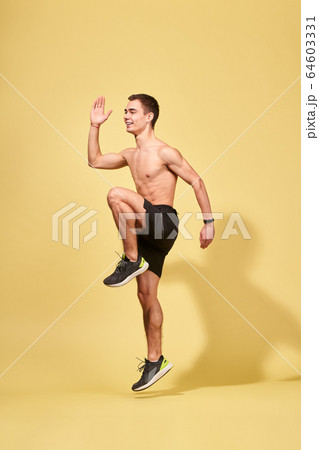 Side view of young sportsman running in studio Side view of young sportsman running in studio 64603331