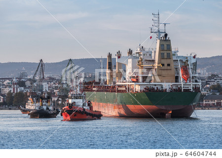 Maneuvers of a huge bulk carrier and tug boats Maneuvers of a huge bulk carrier and tug boats 64604744