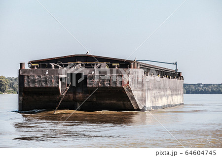 Big dark cargo barge is anchored on the Danube Big dark cargo barge is anchored on the Danube 64604745