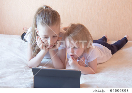 Two girls on the couch with a laptop Two girls on the couch with a laptop 64606393