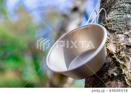 キャンプ素材 木に掛かったシェラカップ キャンプ素材 木に掛かったシェラカップ 64606458