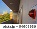 A close up of a red warning light in front of an apartment building in Japan. 64606939