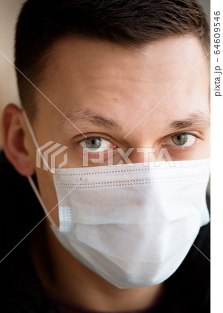 Portrait of a young guy in a protective face mask. New coronavirus (2019-nKoV) infection Portrait of a young guy in a protective face mask. New coronavirus (2019-nKoV) infection 64609546