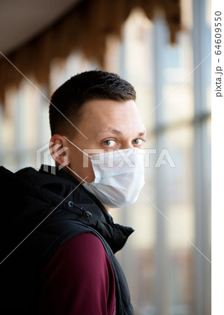 Portrait of a young guy in a protective face mask. New coronavirus (2019-nKoV) infection Portrait of a young guy in a protective face mask. New coronavirus (2019-nKoV) infection 64609550