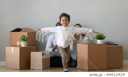 Happy african boy running in new apartment on moving day 64612429