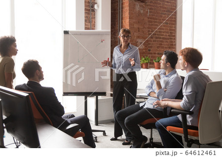 Middle-aged coach mentor gives flip chart presentation training sales team 64612461
