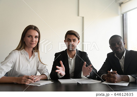 Business team talking looking at camera, videoconference concept, webcam view Business team talking looking at camera, videoconference concept, webcam view 64612635