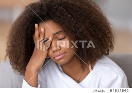 Sad or bored african american teen girl feeling headache sleepiness Sad or bored african american teen girl feeling headache sleepiness 64612646