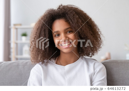 Headshot of smiling african girl looking at camera at home 64613272