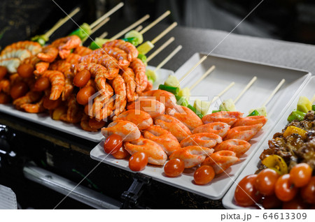 Skewers of grilled seafood skewers with shrimps and lobsters in night market, thailand Skewers of grilled seafood skewers with shrimps and lobsters in night market, thailand 64613309