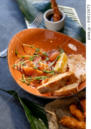 Sliced salmon with toast and dressing on stone background 64613673