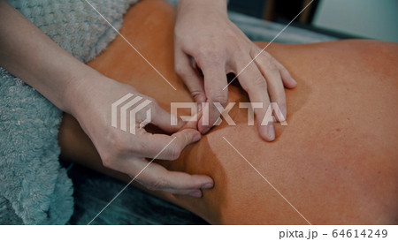 Massage treatment - massage master massaging womans back - squeeze the skin 64614249