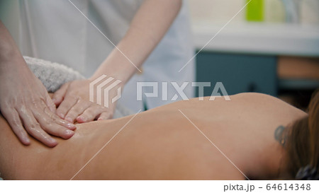 Massage treatment - massage master massaging womans back Massage treatment - massage master massaging womans back 64614348