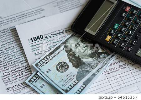 Business and tax concept. Tax form 1040, pen and calculator on the desk. Taxation concept Business and tax concept. Tax form 1040, pen and calculator on the desk. Taxation concept 64615357