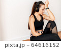Sporty woman with headphones tired after workout 64616152