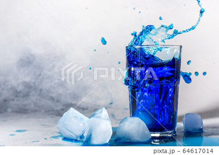 splash chilled refreshing summer blue cocktail with ice cubes on background with place for text splash chilled refreshing summer blue cocktail with ice cubes on background with place for text 64617014