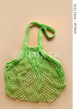 Empty cotton eco green mesh bag on beige. Empty cotton eco green mesh bag on beige. 64617242