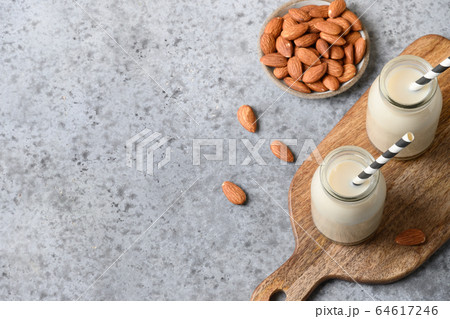 Fresh almond milk in glass bottle and almonds Fresh almond milk in glass bottle and almonds 64617246