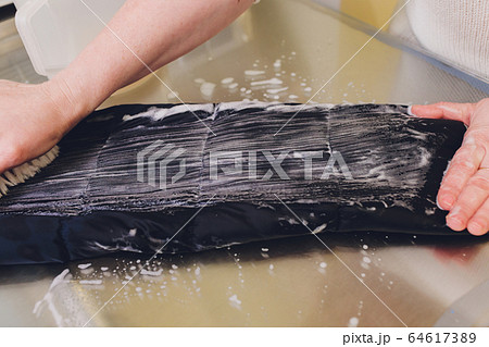 Laundry worker in the process of cleaning fur brush. Laundry worker in the process of cleaning fur brush. 64617389