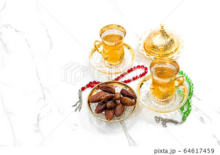 Tea cups dates rosary beads white background 64617459