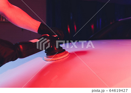 Car detailing - Man with orbital polisher in repair shop polishing car. Selective focus. 64619427