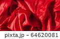 Close-up of folds of red fabric. Rolled up rag. 64620081