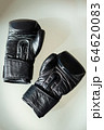 Black boxing gloves lie on a white table. 64620083
