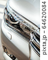 Closeup of a car headlight. Headlight of an expensive new car at a car dealership. 64620084