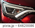Closeup of a car headlight. Headlight of an expensive new car at a car dealership. 64620086