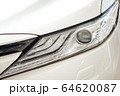 Closeup of a car headlight. Headlight of an expensive new car at a car dealership. 64620087
