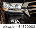 Closeup of a car headlight. Headlight of an expensive new car at a car dealership. 64620088