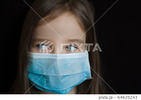 Studio portrait of little blond girl on black backgound in blue surgical disposable mask for protection of Coronavirus Covid-19 during self-isolation while stay home Studio portrait of little blond girl on black backgound in blue surgical disposable mask for protection of Coronavirus Covid-19 during self-isolation while stay home 64620243