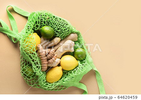 Green mesh bag with vegetables, ginger, lemon Green mesh bag with vegetables, ginger, lemon 64620459