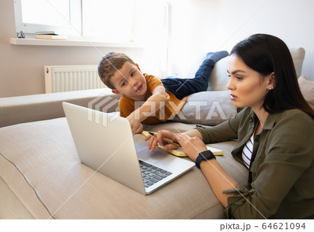Cute little boy and his mother using laptop at home Cute little boy and his mother using laptop at home 64621094