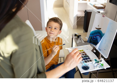 Adorable little boy painting picture with his mother at home Adorable little boy painting picture with his mother at home 64621137