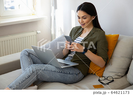 Amazed pretty lady using smartphone at home 64621173