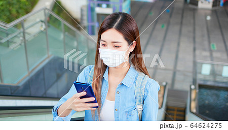 woman use phone with mask 64624275