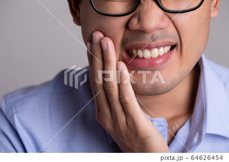 Young asian man with sensitive teeth or toothache. 64626454