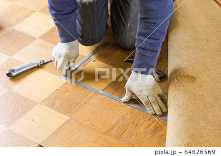 差し金で床材を採寸している大工　床張替え 64626569