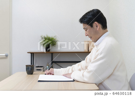 ノートに筆記をする中高年男性 64630118