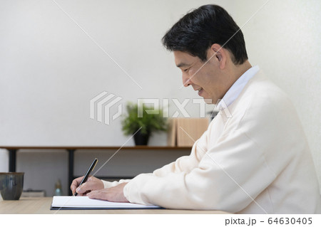 ノートに筆記をする中高年男性の横顔 64630405