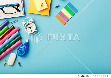 Office supplies lie on a blue background. To study 64635361