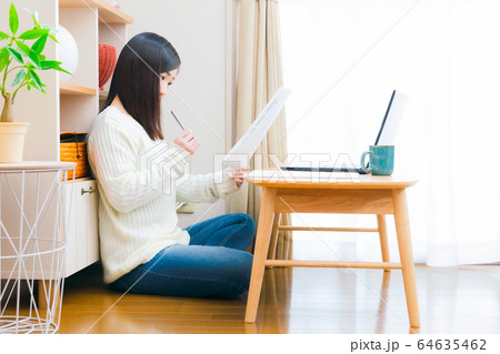 自宅で書類をチェックする女性　コピースペース 64635462