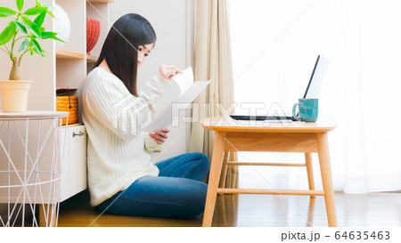 自宅で書類をチェックする女性 コピースペース 16:9 自宅で書類をチェックする女性 コピースペース 16:9 64635463