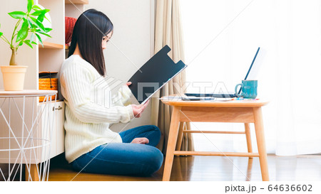 自宅で書類をチェックする女性　コピースペース　16:9 64636602